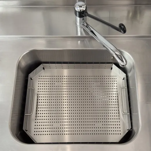 Edelstahl Siebeinsatz SEB-50x50-Uni 480x480x60/106 mm fr Splbecken 50x50 cm. Ausfhrung in Edelstahl 1.4301 mit gelochtem Boden und Rand, seitlichen Bgelgriffen und vier Kunststofffen. Praktisches Anwendungsbeispiel im Edelstahlspltisch.